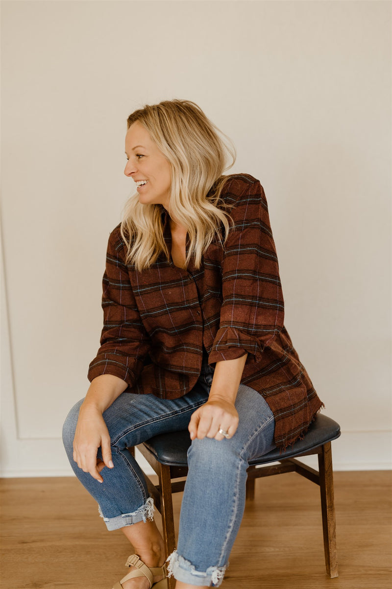 blonde in relaxed wine colored flannel and light wash blue jeans