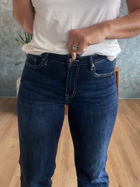 Person wearing blue jeans and a white shirt indoors.