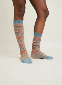 Colorful blue striped socks worn by a person on a white background